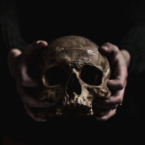 Manos sujetando calavera